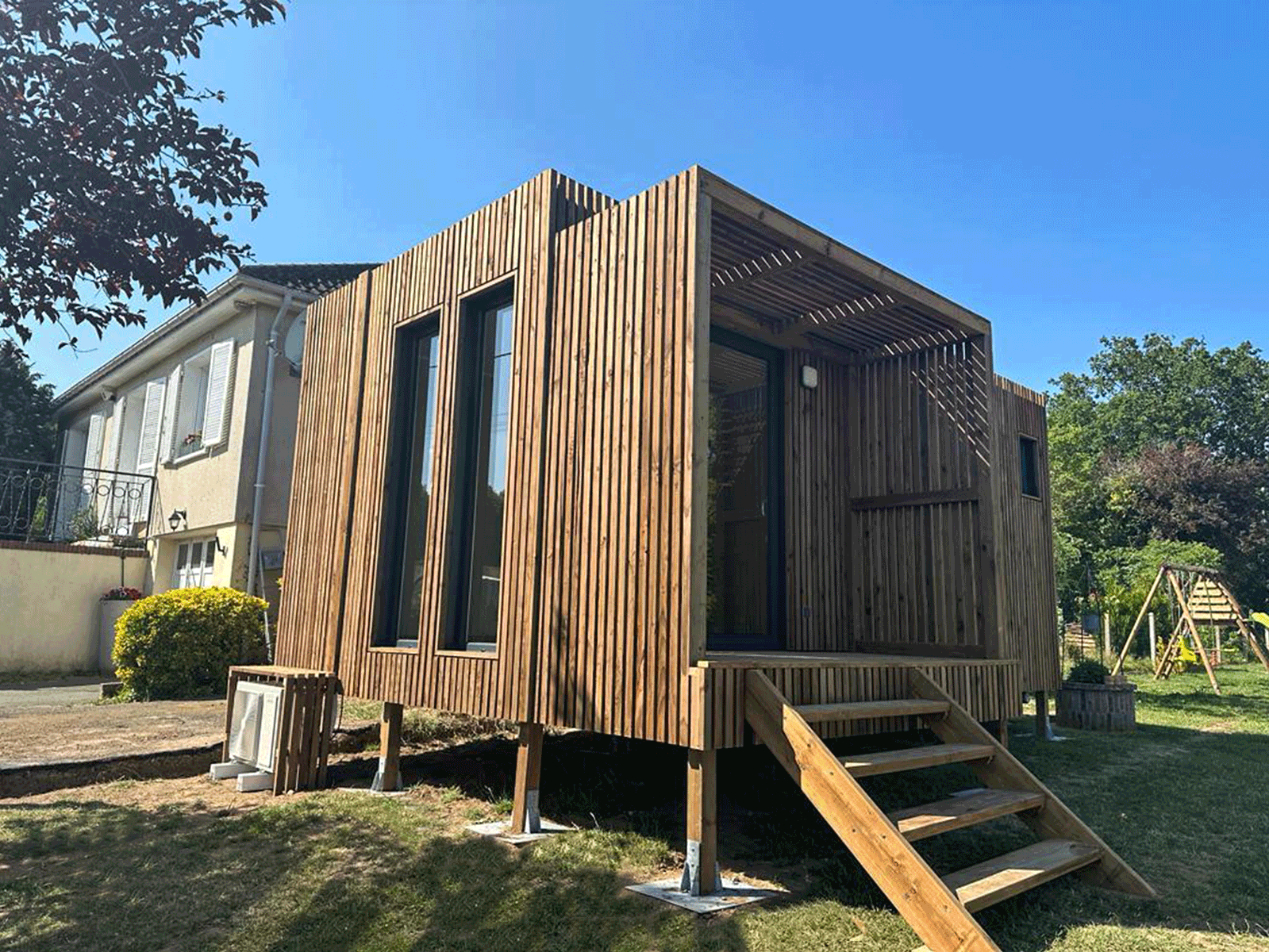 Studio en bois dans un jardin avec un escalier