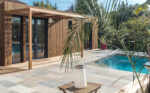Un pool house en bois au bord d'une piscine