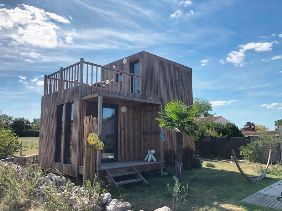 Un studio de jardin en bois au bord d'une piscine
