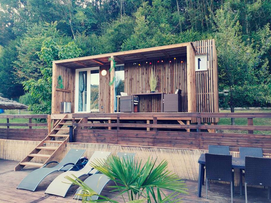 Un studio de jardin en bois au bord d'une piscine